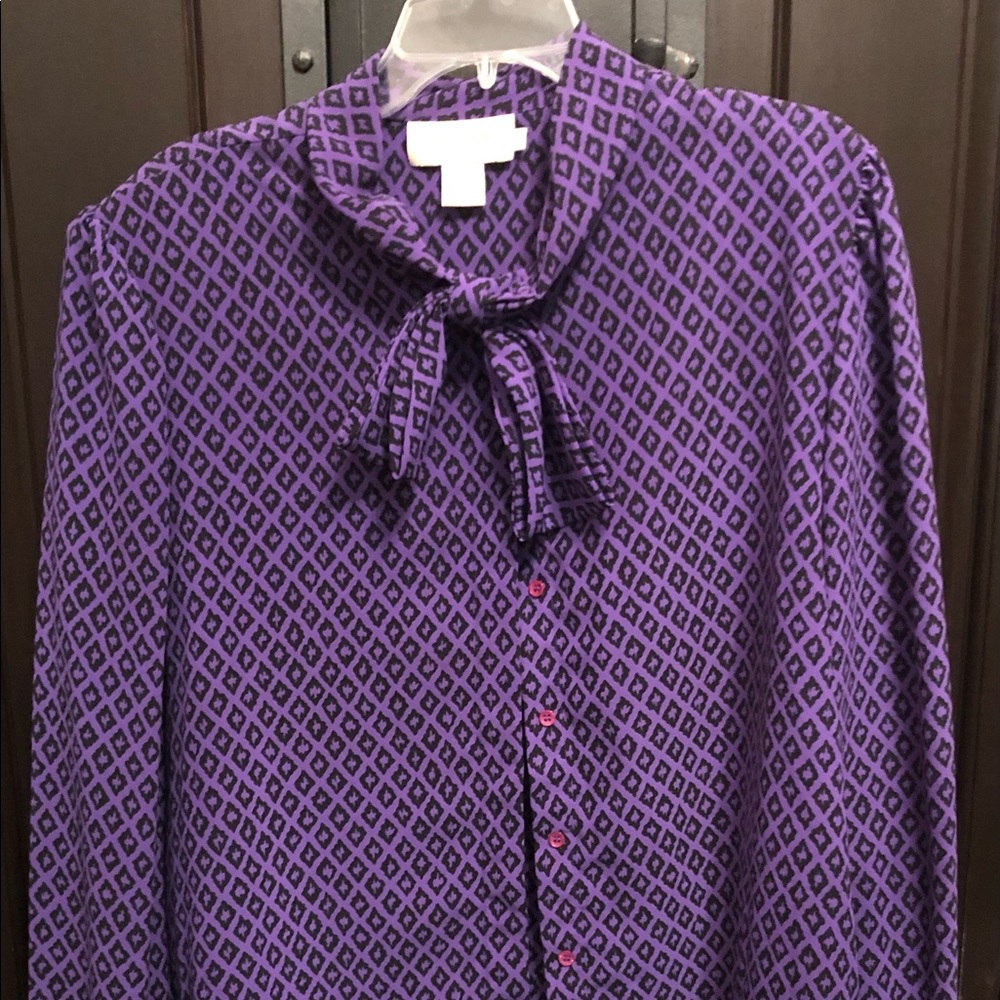 Purple blouse with black designs and accent tie/bow.